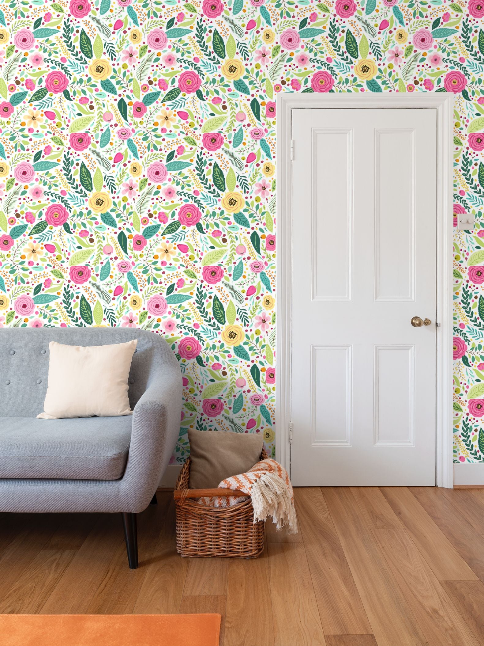 Vibrant pink and yellow garden floral wallpaper in a modern living room featuring a grey sofa, wicker basket, and white panel door.